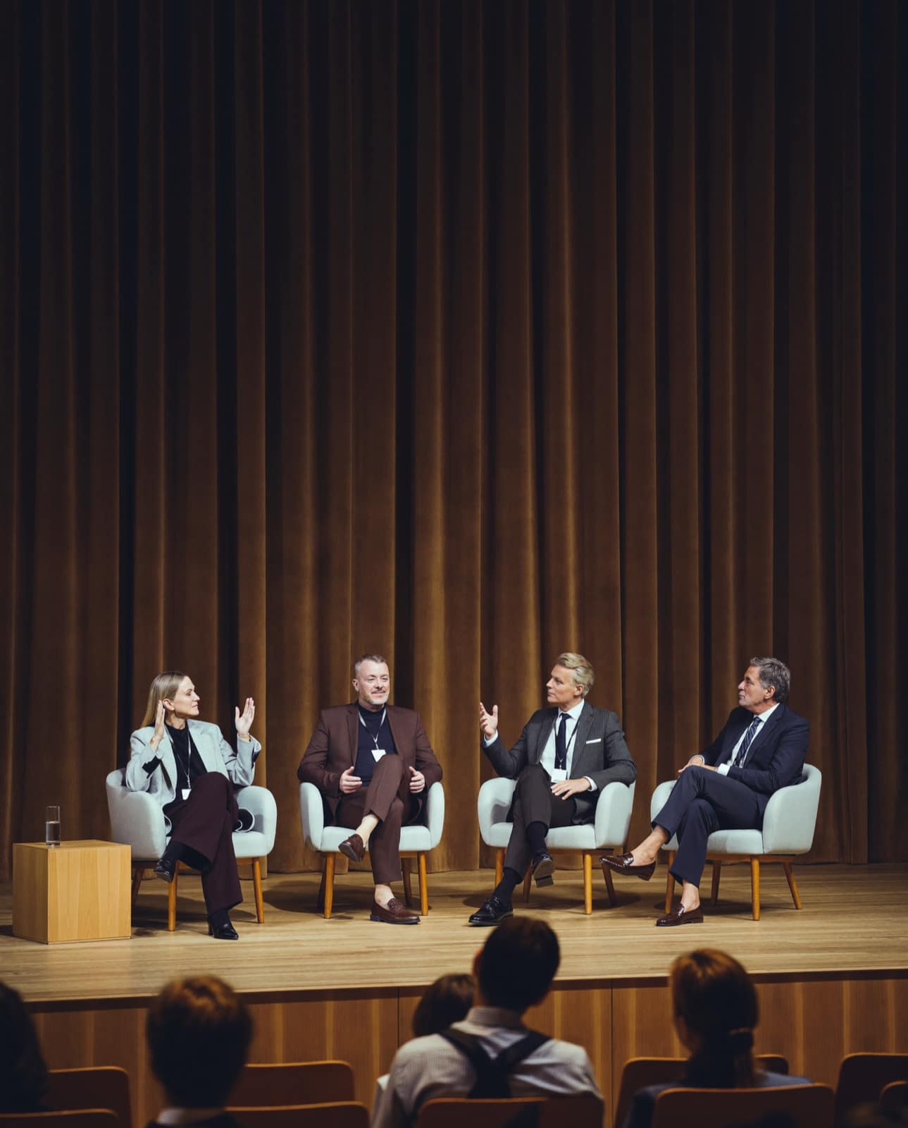 Conference panel on a warmly lit stage — corporate event coverage by Basil Studios